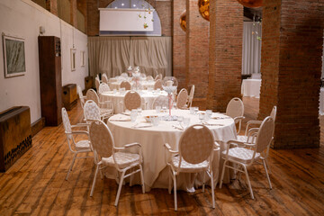 Elegant Round Dining Tables Set For A Formal Event With Soft Lighting And A Warm Rustic Atmosphere