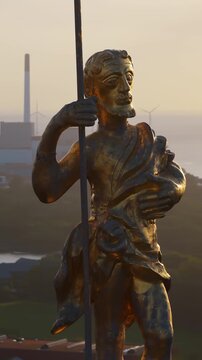Aerial drone view of the golden statue atop a sphere on the Church of Our Saviour overlooking the Copenhagen skyline, with Frederik's Church dome in the background in Denmark. Vertical