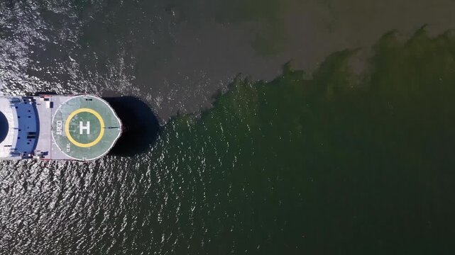 Sleepy Hollow, United States - 23 September 2025: Aerial view of a large industrial ship with a helipad on the deck, contrasting against the dark water.