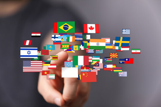 Image shows a hand interacting with multiple flags from different countries, symbolizing global cooperation, international relationships, and un