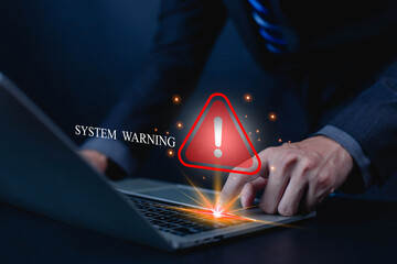 Businessman pressing laptop keyboard with glowing red system warning alert sign. Concept of cybersecurity risk, computer error, data protection failure, digital system security breach in technology.