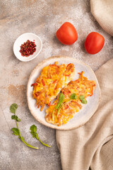 baked chicken meat with cheese and tomatoes on brown concrete. top view, flat lay, close up