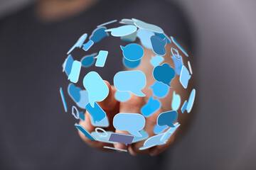 A hand holds a 3D sphere of speech bubbles, depicting worldwide communication, social media, or global networking in digital space.