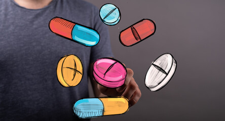 Person interacting with colorful pills and capsules. Healthcare, medicine, pharmacy concept.