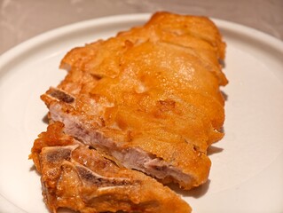 close up golden fried pork chop on white plate