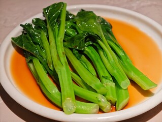 stir fried chinese kale with sauce on white plate
