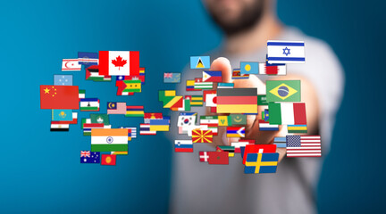 Conceptual image showing various national flags floating, with a hand pointing at them. Represents...