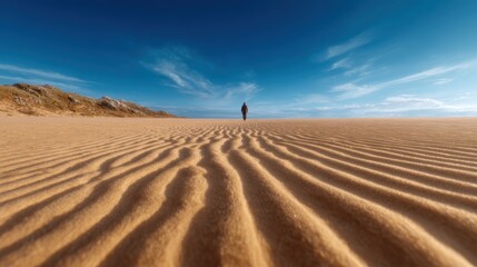 A lone figure walks through a vast desert, with undulating sand dunes and a dramatic sky that captures the essence of solitude and exploration in nature's beauty.