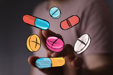 Image of hand interacting with colorful pills and capsules.  Perfect for healthcare, pharmacy, and medicine concepts.
