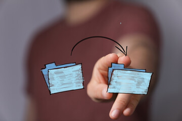 Image of a hand moving files between folders. Ideal for concepts of data transfer, sharing, and online collaboration.