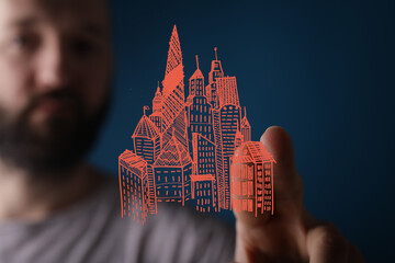 Hand drawn cityscape on fingertip, representing urban planning, real estate, and modern city growth.