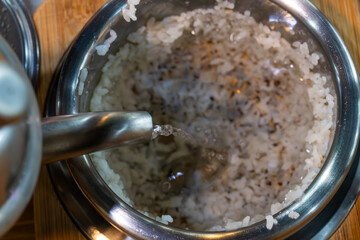 pouring water into the scorched rice in the pot