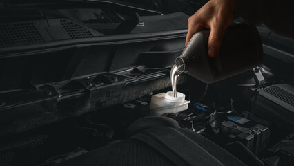 Pouring clear brake fluid into car reservoir during professional maintenance. Concept of automotive service, precision safety system, and technical reliability training.