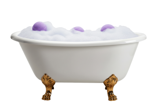 Isolated clawfoot bathtub filled with white foam bubbles and three purple bath bombs