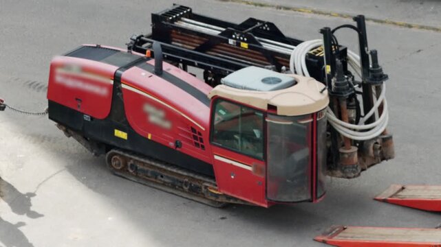 A lowboy trailer is being used to transport a modern horizontal boring machine for laying water pipes and electrical cables underground, renovation work