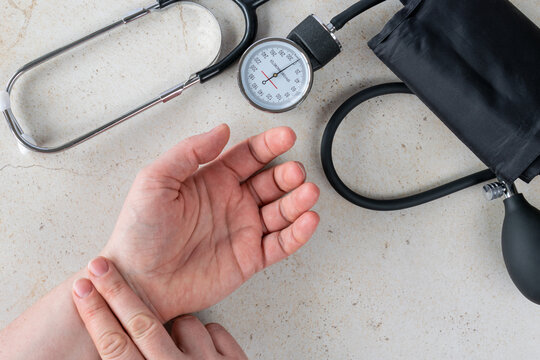 Doctor measuring blood pressure with tonometer and stethoscope on patient's hand, healthcare and medical diagnosis concept showing blood pressure control, prevention and heart care at home or clinic