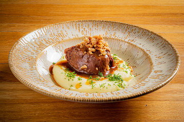 Tender meat on smooth mashed potatoes, topped with herbs and crispy bits, creates a delicious meal
