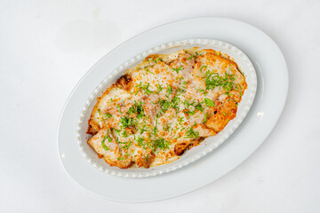 A delicious baked dish topped with melted cheese and herbs, perfect for sharing at a cozy meal