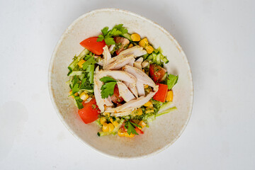 A vibrant mix of lettuce, tomatoes, corn, and grilled chicken offers a refreshing lunch option