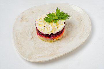 A beautiful layered salad is artfully presented on a simple white plate, highlighting rich colors