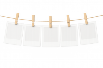 Blank instant film frames hanging on a clothesline with wooden clothespins, transparent background