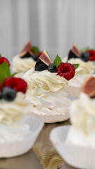Cream cakes with fruits on the wedding table. Raspberries, blueberries, figs, cream, dessert, sweets