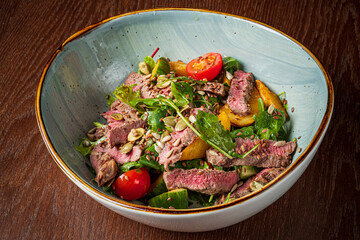Colorful salad features tender steak atop fresh greens and ripe cherry tomatoes, perfect for lunch