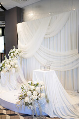The wedding background is decorated with white and blue flowers