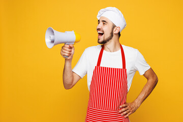 Young happy housewife housekeeper chef cook baker man wear red apron toque hat hold megaphone...