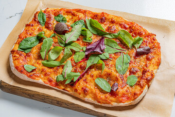 Delicious flatbread pizza is garnished with fresh greens, ready to be enjoyed at any mealtime