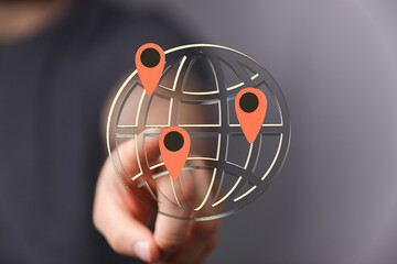 Hand pointing at digital globe with location markers. Global network, connectivity, and worldwide reach concept.