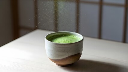 A traditional Japanese matcha tea with bamboo whisk and powder floating above a ceramic cup in soft natural light