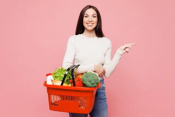 Young woman wear white casual clothes hold brown orange basket with food products point index...