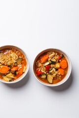 Vegetarian bean tomato soup with vegetables on white background.
