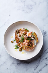 Whole baked potato stuffed with salmon, yogurt sauce and capers.