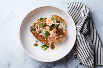 Whole baked potato stuffed with salmon, yogurt sauce and capers.