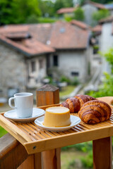 breakfast with creamy pudding panna cotta, fresh croissants, and coffee, Italian Morning, rustic village from balcony, Authentic Italian Charm