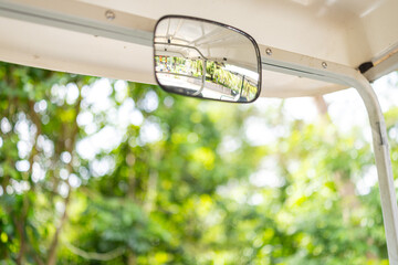 Golf cart front view and rearview mirror,driver perspective car in golf course blur background © banjongseal324
