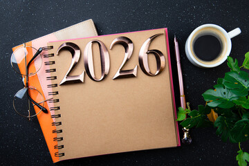 New year goals 2026 on desk. 2026 resolutions list with notebook, plant on black table. Resolutions, plan, goals, action, checklist, idea concept. New Year 2026 resolutions, copy space