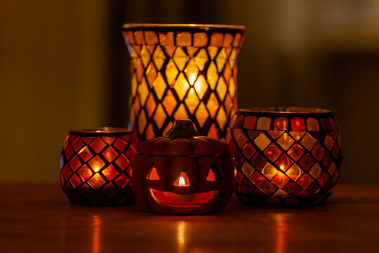 Halloween pumpkin tealight and candles glowing against a dark background in a home
