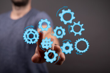 A hand interacts with a cluster of digital gears, representing teamwork, innovation, and the digital age, perfect for tech and business concepts