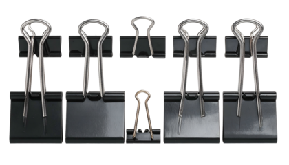 Variety of black and one gold binder clips on dark surface