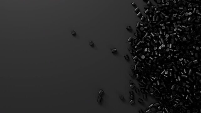 Closeup top view on black plastic polypropylene granules heap rotating on black backdrop, masterbatch polymer grain pile. HDPE or PVC resin pellets.