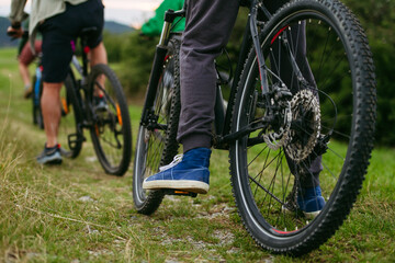 Fototapeta premium Cyclists riding mountain bikes on grassy trail.