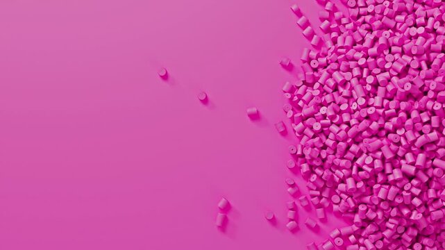 Closeup top view on pink plastic polypropylene granules heap rotating on pink backdrop, masterbatch polymer grain pile. HDPE or PVC resin pellets.