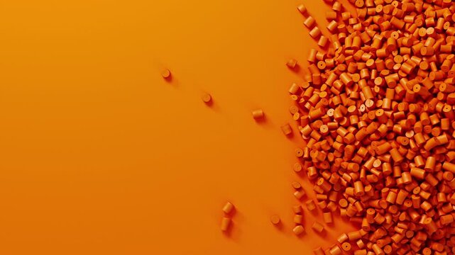 Closeup top view on orange plastic polypropylene granules heap rotating on orange backdrop, masterbatch polymer grain pile. HDPE or PVC resin pellets.