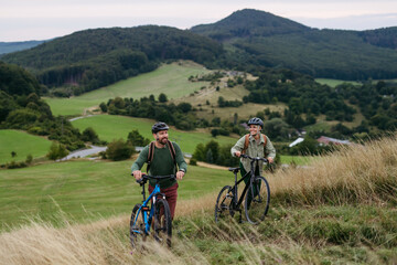 Obraz premium Couple cycling together in nature, smiling and enjoying outdoor adventure.