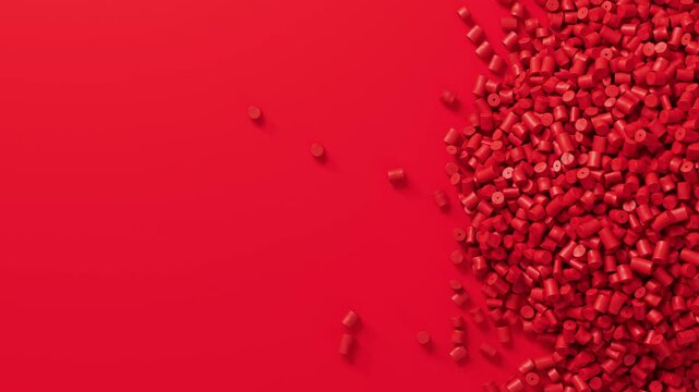 Closeup top view on red plastic polypropylene granules heap rotating on red backdrop, masterbatch polymer grain pile. HDPE or PVC resin pellets.