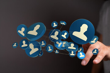 Hand interacting with connected profiles on a digital interface. Illustrates communication, social network concept. 144 characters max.