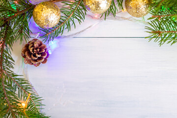 Spruce branches with golden balls, cones and a garland